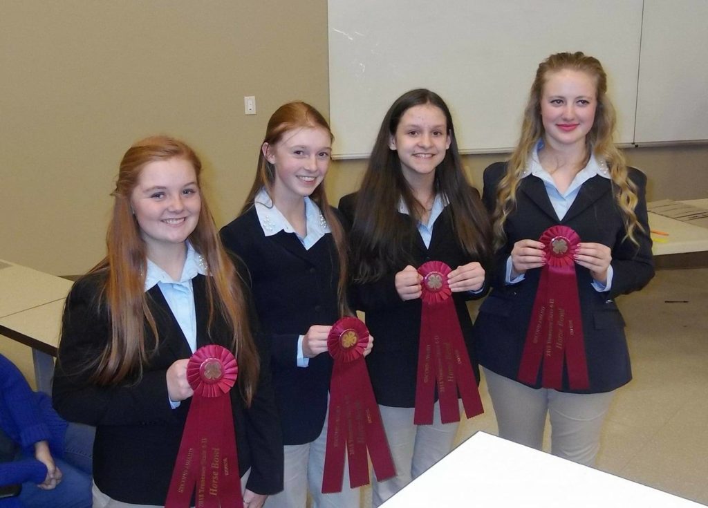 4 girls holding ribbons from a contest