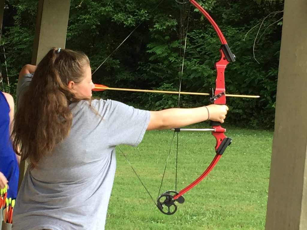 Girl shooting at a target with a bow and arrow